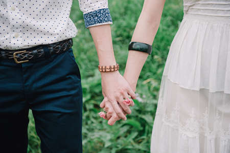 Lovers holding hands with a flower ringの写真素材