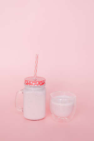 Strawberry milk in a glass cup on a pink backgroundの写真素材