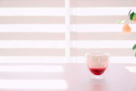 Glass cup with red wine on white table indoors.の写真素材