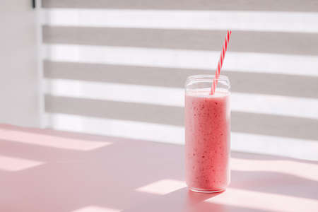 Glass of tasty strawberry smoothie on table indoors, space for textの写真素材