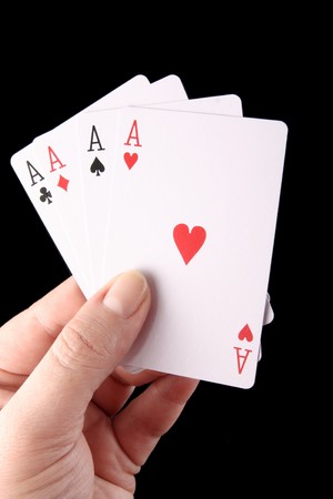 Female hand with playing cards isolated on black
