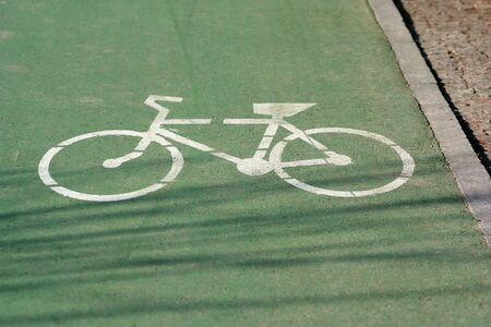 Green bicycle track with white signの写真素材