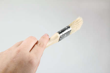 Hand with brush and red paint の写真素材