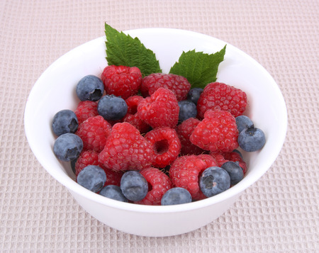 fresh raspberries and berry on a bowlの写真素材