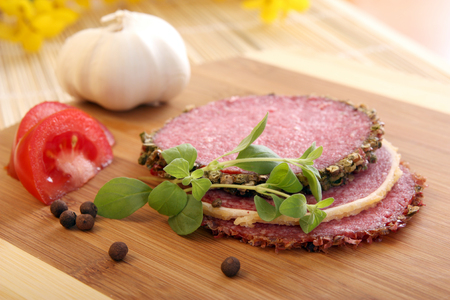 Slices of salami on wooden tableの写真素材