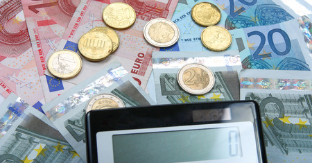 Calculator with Euro notes and coins. Finance concept. Closeup.の写真素材