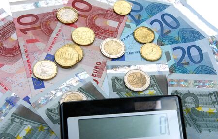 Calculator with Euro notes and coins. Finance concept. の写真素材