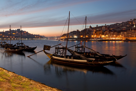 PORTO, PORTUGAL - 07.10.2016, old town cityscape on the Douro River with traditional Rabelo boats, with barrels advertising Porto alcoholの写真素材