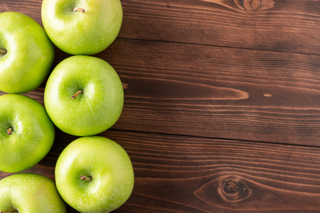 Green apples on wooden tableの写真素材