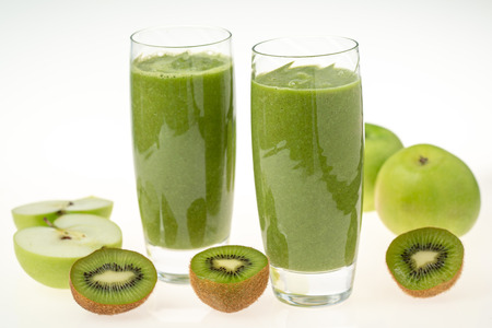 Two glasses of kiwi and apples smoothie isolated on white backgroundの写真素材