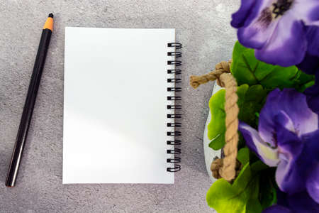 Note book with pen and potted plant on marble table. Directly above. Copy space.