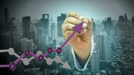 Businessman holding a touch pen The graph shows the goal setting and choosing the ultimate goal on the background of urban society.の写真素材