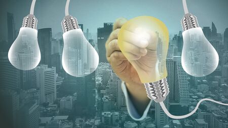 Businessmen touch light bulbs that emit light,concepts,choose business lighting.の写真素材