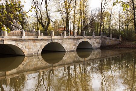 Poland,Warsaw.Lazienki Royal park.View on the arcade bridge with  the statue of King John III Sobieski in the background.Photo was taken in April 2015.Horizontal view.の写真素材