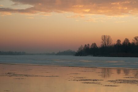 Poland in winter.Daw on the Bug river.Highlighted in red clouds and water.Horizontal view.の写真素材