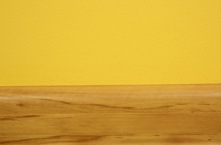 Wooden skirting board in the color of light alder, connecting the yellow wall with floor.Close,horizontal view.の写真素材