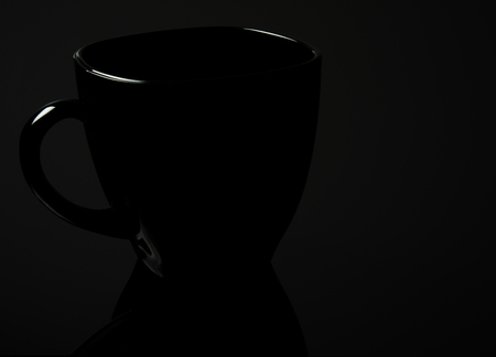 Black cup of a mirror at the bottom, gently lit, isolated on a black background.Horizontal view.の写真素材