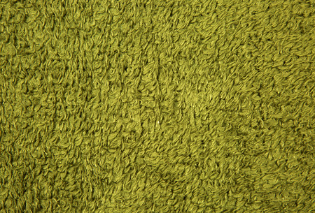 A sheet of thick, green woolen fabric with long nap and clearly visible texture and fibers. Ideal background or invoice.Close, horizontal view.の写真素材