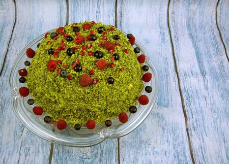 Beautiful, green, spinach cake decorated with wild blueberries in stagnant springform pan on a wooden countertop, Vintage.Horizontal view.の写真素材