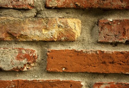 Fragment of an old wall of red brick with visible defects and small cracks. Interesting background...