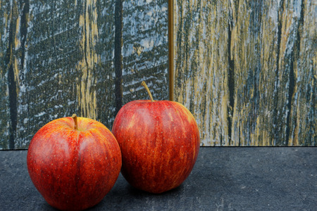 Two, fresh red apples on an old stone kitchen counter in vintage style. Horizontal viewの写真素材
