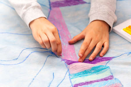 Simple kids hands drawing with precision on a huge canvas using oil pastels, coloring detail,...