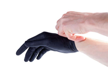 Man safely removing, taking off black protective disposable medical rubber gloves hand gesture, isolated on white, cut out, closeup. Safety, hygienic removal, disposal of one time use latex glovesの写真素材
