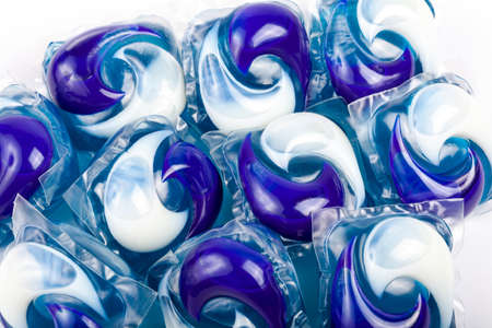 Many simple blue white detergent pods. Lots of washing machine pods macro, closeup. Home domestic equipment, cleaning washing dishes and doing laundry, group of home chemicals abstract conceptの写真素材