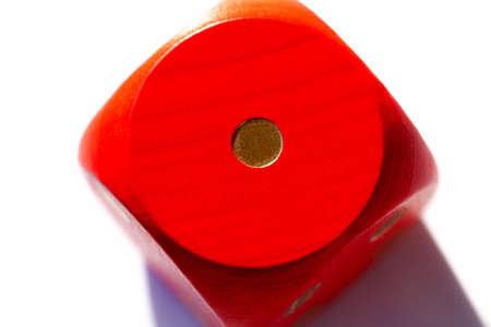 Simple red game dice showing one. Number 1 on a big wooden playing dice on white background, macro, extreme closeup. Low score, lost game, bad luck and misfortune in gambling, gaming abstract conceptの写真素材