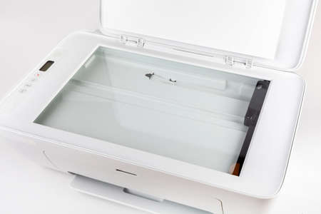 Photocopier with open lid, glass area surface visible. Small home use scanner, copier, modern white printer tool top view closeup Scanning and copying documentation, small office peripheral deviceの写真素材