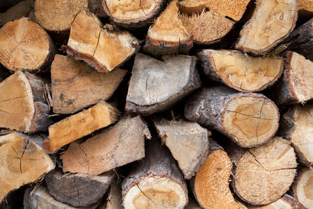 A pile of cut fire wood abstract texture. Lots of stacked wooden logs piling, tightly alligned....