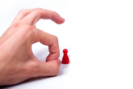 Hand flicking a single red game piece on white background, eliminationの写真素材
