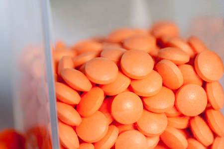 Orange pills in a glass containter, close-upの写真素材