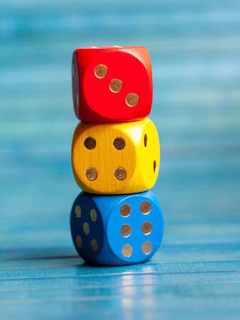 Three colorful board game dice stack. Multi colored dice laying on top of each other. Kids early school education symbol, simple educational materials, learning numbers, fun maths abstract conceptの写真素材