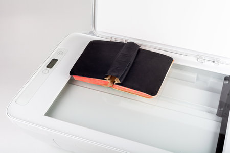 Office copying machine scanning a small old vintage book laying on the glass surface