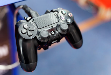 PS4 controller closeup, shallow depth of field. PlayStation 4 pad plugged in up close. Console...