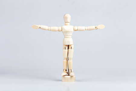 Wooden figurine, small painting mannequin figure model, man with his arms spread wide, power pose, human body language and personal space proxemics scientific cultural research abstract conceptの写真素材