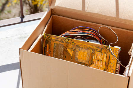 Throwing away electronic waste, obsolete pc components in a carton box, electro trash recycling, old...