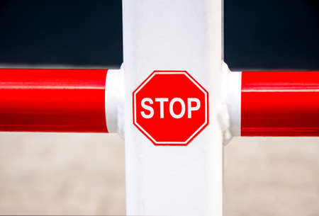 Simple small red stop sign, closeup, detail. Car parking spot octagon stop symbol up close, object, nobody. Stopping, slowing down, traffic safety warning, caution abstract concept, transportationの写真素材