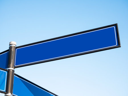 Empty blank blue city street signpost, guidepost, sign post with space for text inside, clear blue sky, nobody. Urban street name simple road sign, guide post object detail, closeup, copy spaceの写真素材