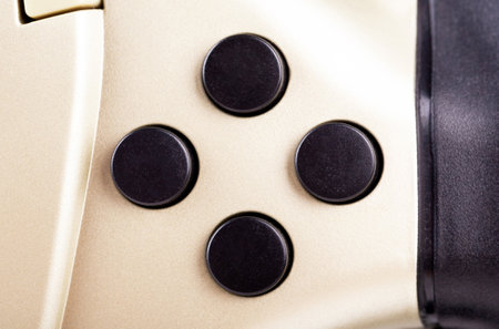 Four round blank, empty buttons on a simple game controller, object detail, extreme closeup, front...