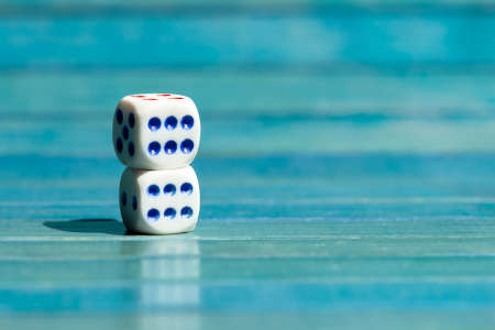 Two small little game dice showing six on top of each other, stacked tiny dice with number 6 on them, closeup. Winning, success, luck and good great odds simple abstract concept, lucky throw, nobodyの写真素材