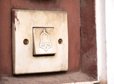 Old retro doorbell bell symbol button detail, macro, extreme closeup, nobody. Entrance door house bell signal system vintage antique switch object, bell icon, waiting to enter abstract conceptの写真素材
