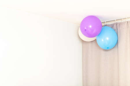 Three festive balloons on the wall near the ceiling, abstract universal holiday birthday background, copy space for text, nobody. Inside of the room at home seasonal house party backdrop, celebrationの写真素材