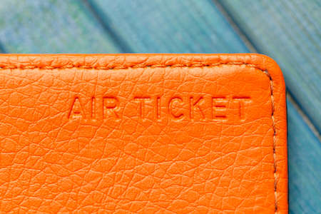 Air ticket concept, plane ticket orange wallet compartment object macro, extreme closeup, nobody. Flying, airplane transportation air transport tickets place, last minute simple abstract conceptの写真素材