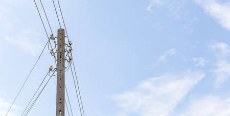 Old fashioned retro medium voltage power lines single pole with cables, wires. Blue sky simple high resolution wide background, banner, copy space. Power generation and transmission industry conceptの写真素材