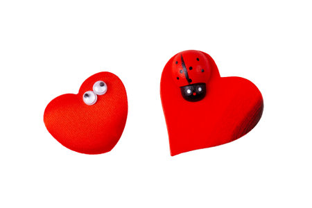 Two little funny quirky red hearts, heart pair, objects isolated on white background, cut out, nobody. Valentines day, love symbol concept, design element. Heart with eyes and heart with a ladybugの写真素材