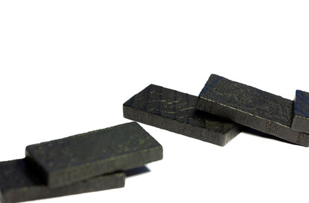 Lots of domino pieces fallen down, collapsed black dominoes, tiles laying around, closeup, white background. Falling, collapsing, built structure losing stability aftermath abstract concept, nobodyの写真素材