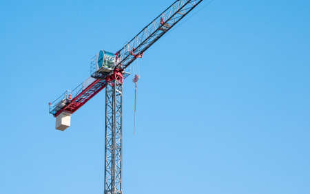 One single simple minimal industrial construction crane object isolated on blue clear sky background, nobody, no people, construction site industry business symbol, abstract conceptの写真素材