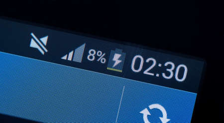 Smartphone almost empty battery charging indicator, low battery level, rechargeable batteries in mobile phones, electronics, electronic device charger connected simple concept, display extreme closeupの写真素材